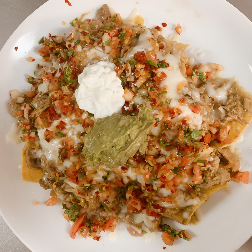 Mi Favorito Mexican Restaurant's nachos, topped with melted cheese, pico de gallo, sour cream, and guacamole.